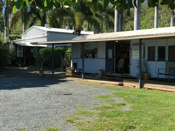 Buildings With a Porch and Gravel Parking Area, Surrounded by Trees — Bayview Canine Lodge In Habana, QLD