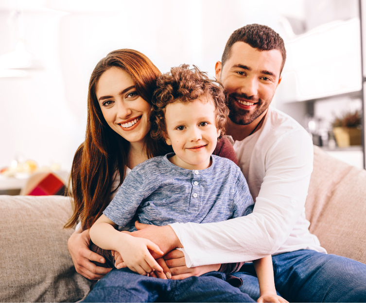 A picture of a woman and a man with a little boy on their lap.