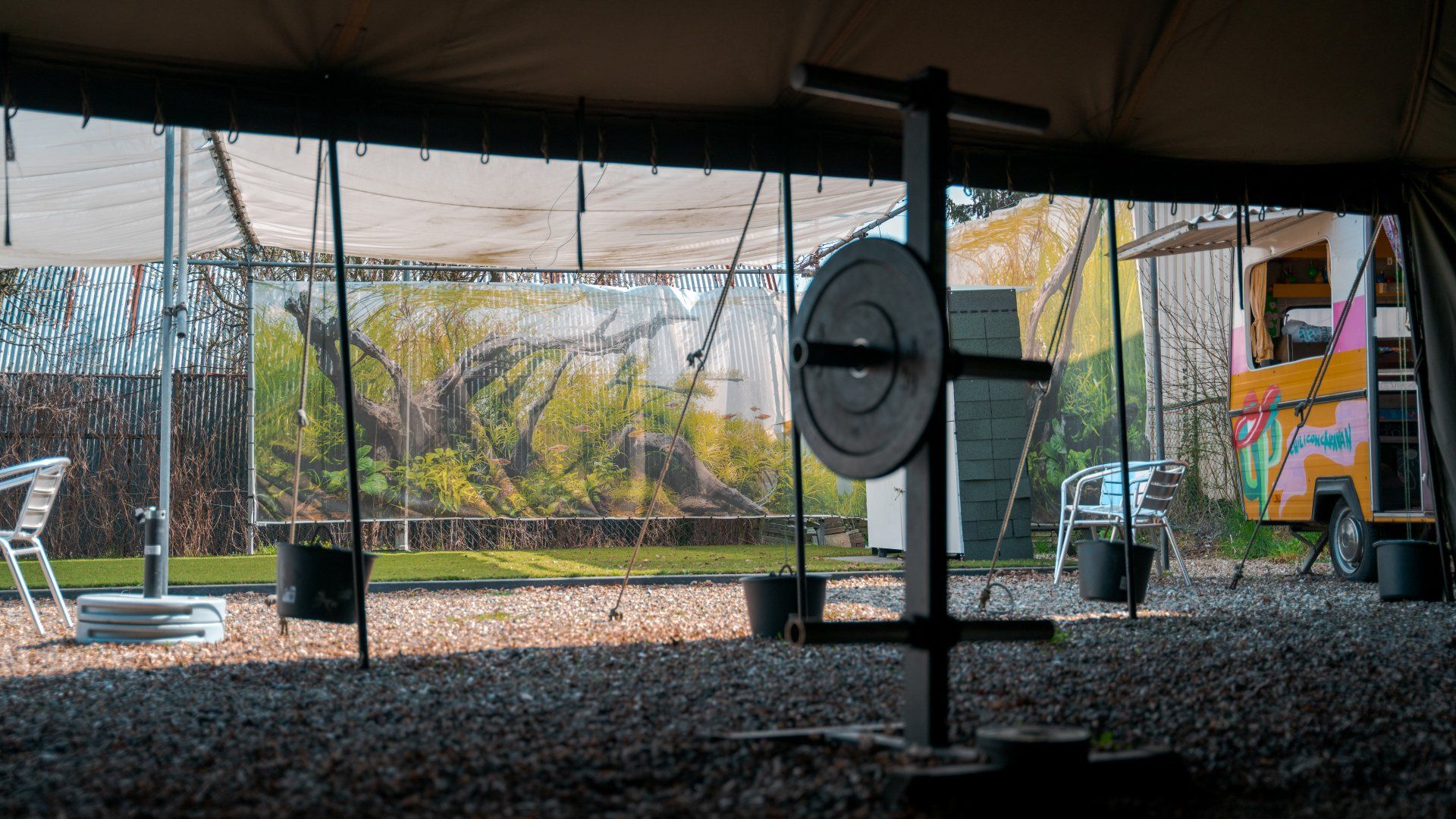 Aan het plafond van een tent hangt een groot metalen voorwerp.