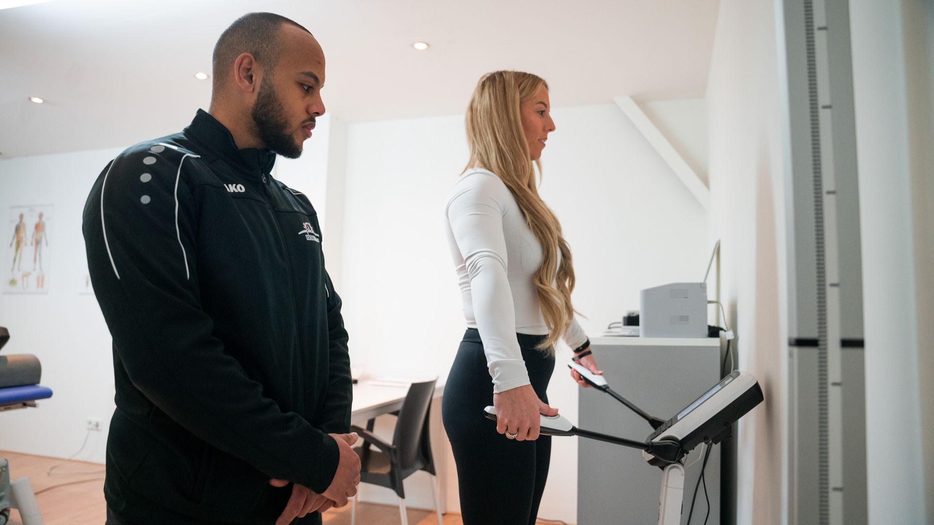 Een man en een vrouw staan naast elkaar voor een machine.