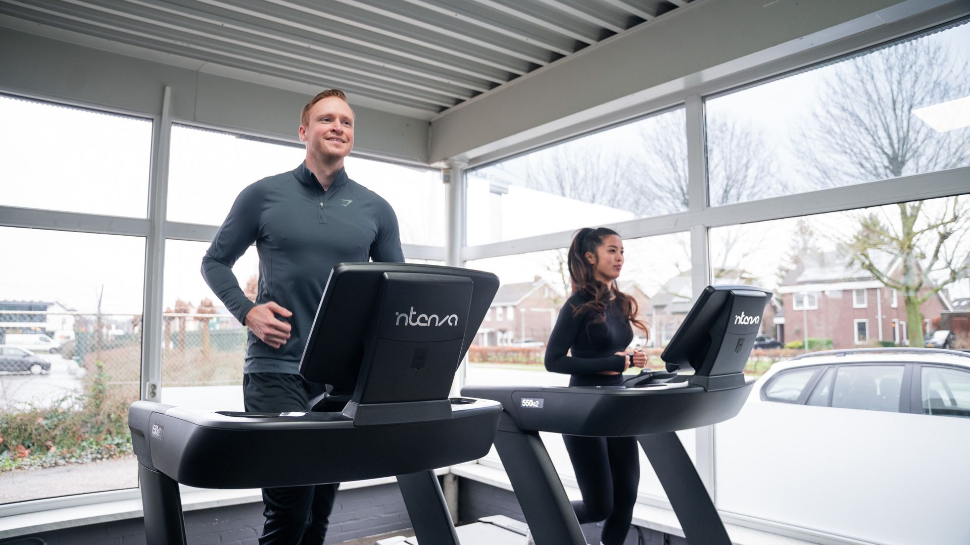Een man en een vrouw lopen op een loopband in een sportschool.