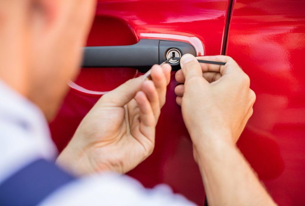 Person unlocking a red car door with a key fob