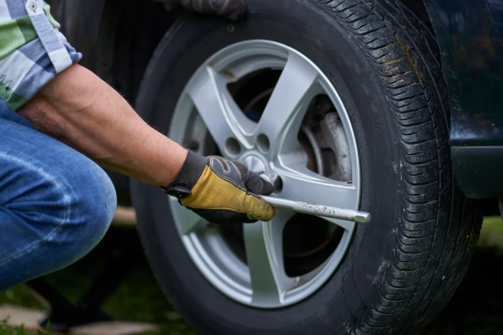 Person using a wrench to tighten a car wheel lug nut.