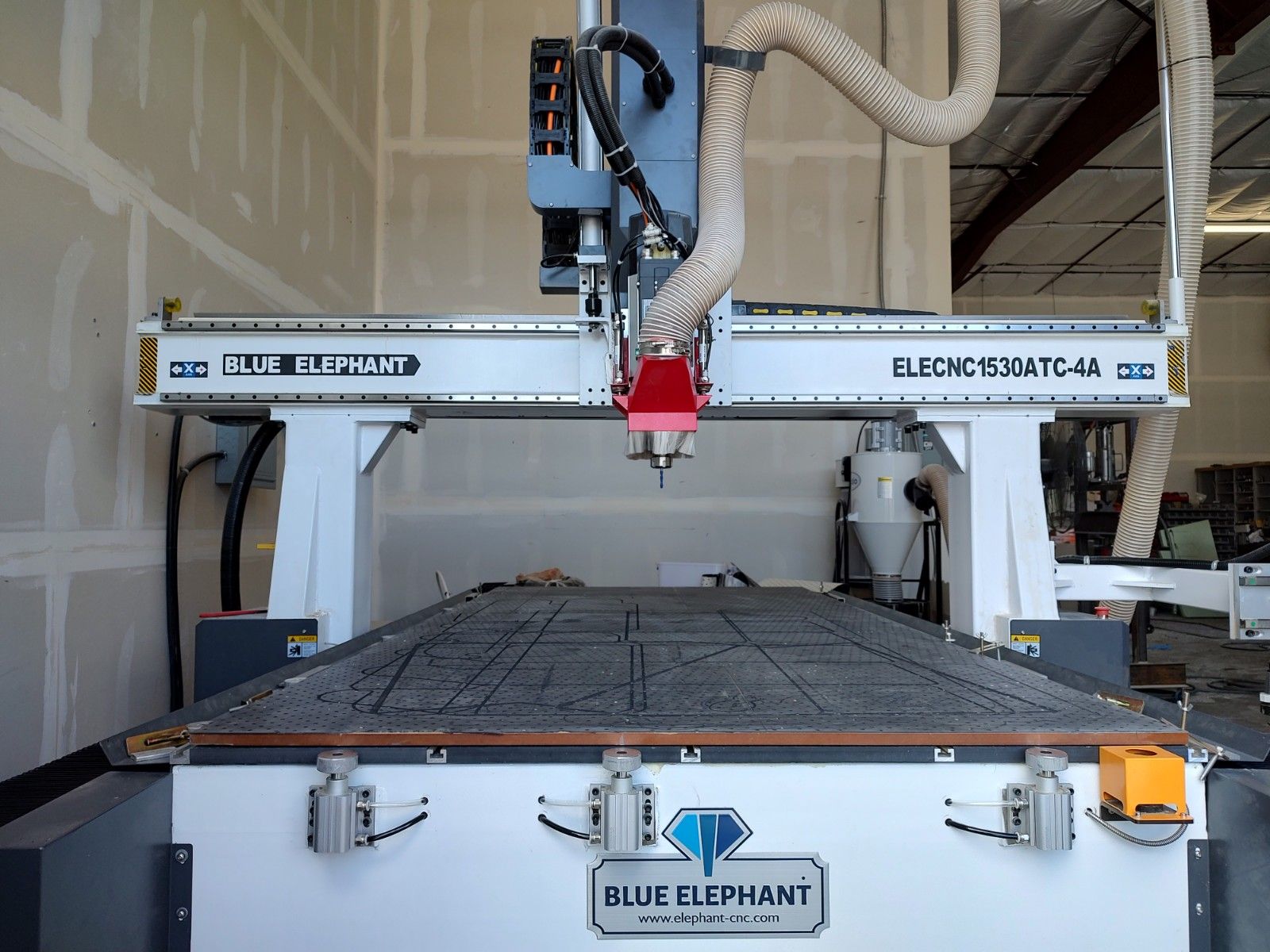 Blue Elephant CNC router machine with red spindle over a worktable in a workshop