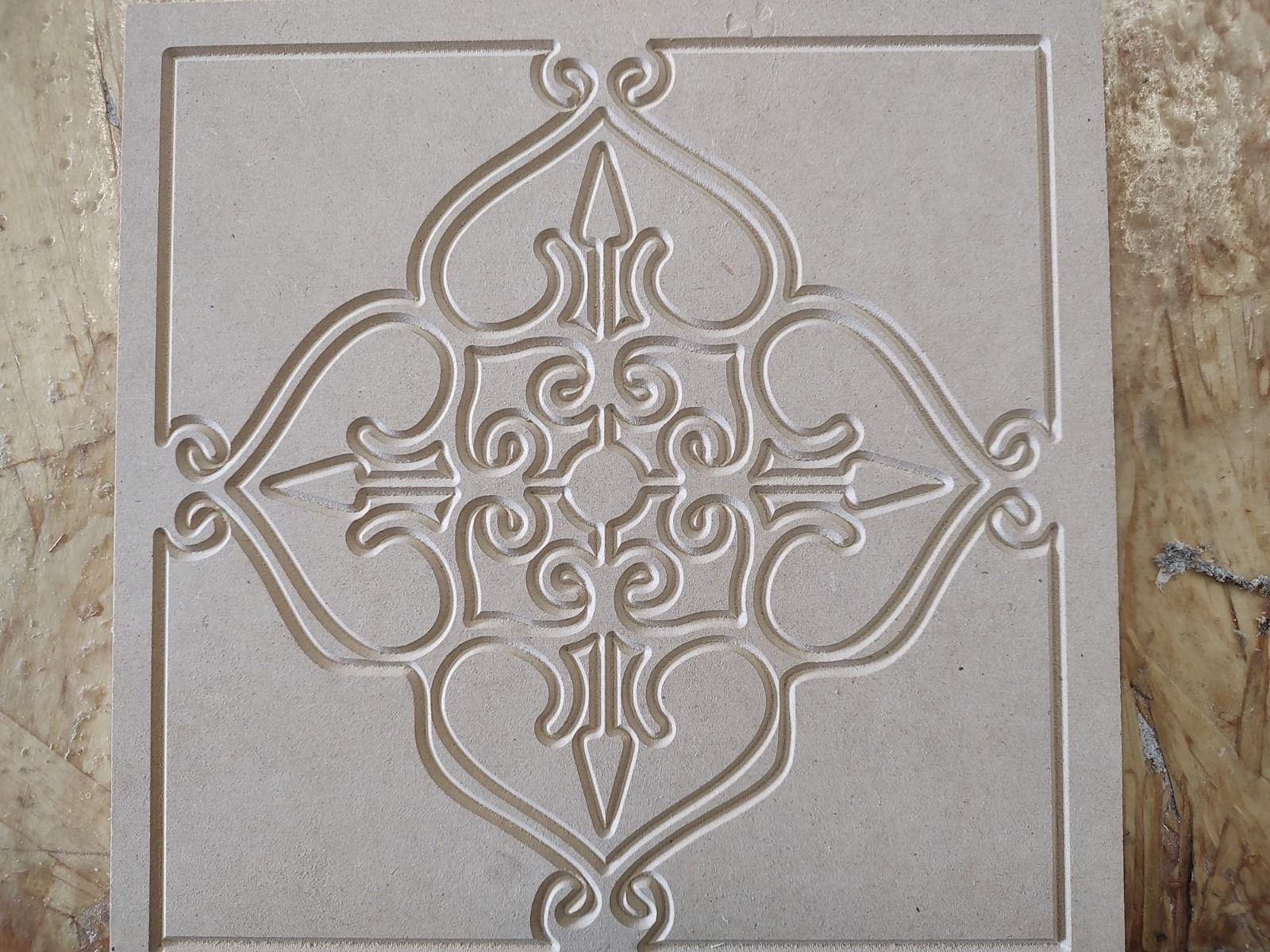 Beige decorative tile with embossed symmetrical floral and geometric pattern
