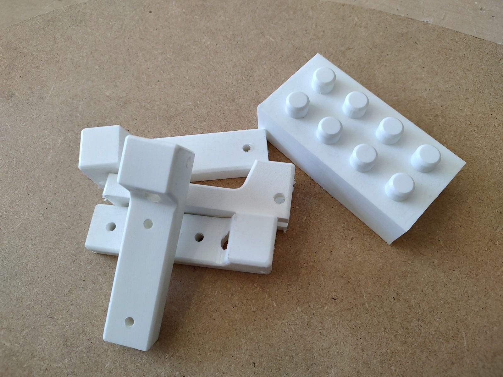 White plastic LEGO-style blocks scattered on a tan surface