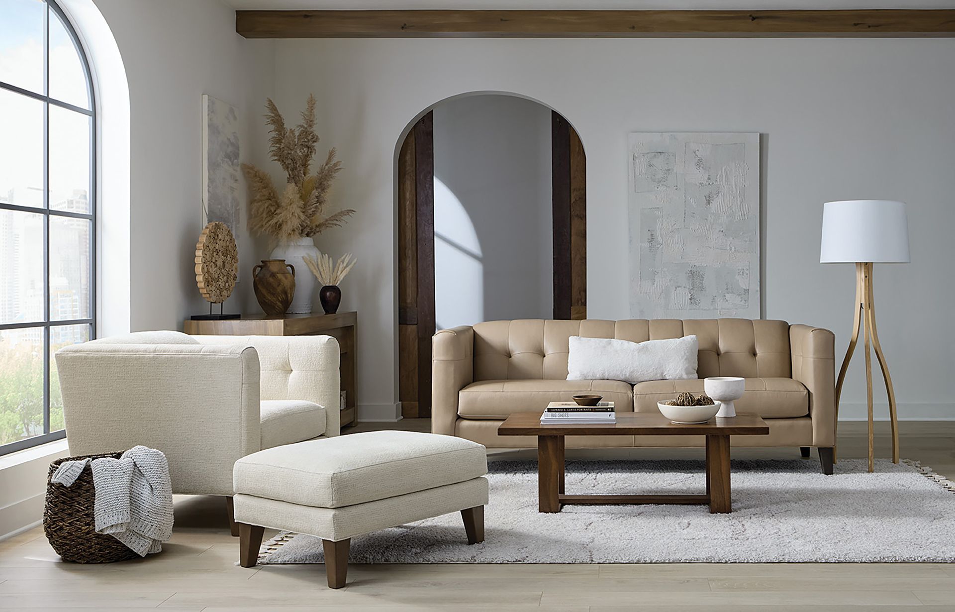 Living room with beige sofa, armchair, ottoman, wooden coffee table, and tall lamp.