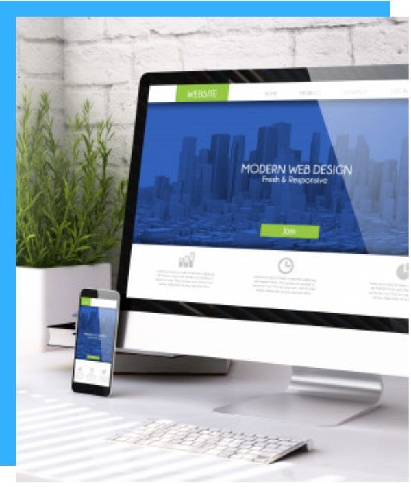 A computer and phone display a website with a blue and white design, on a desk next to a plant.