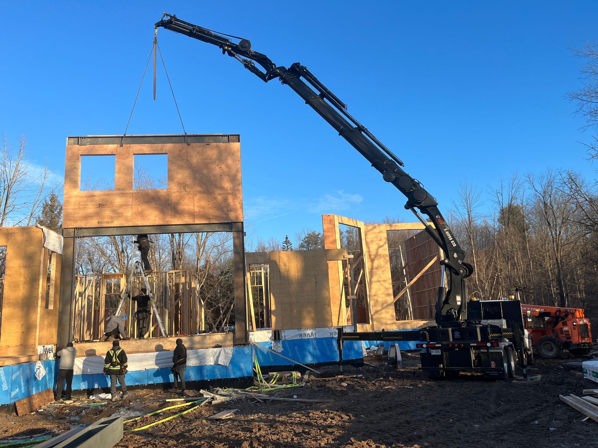 A construction site with a crane lifting a wall