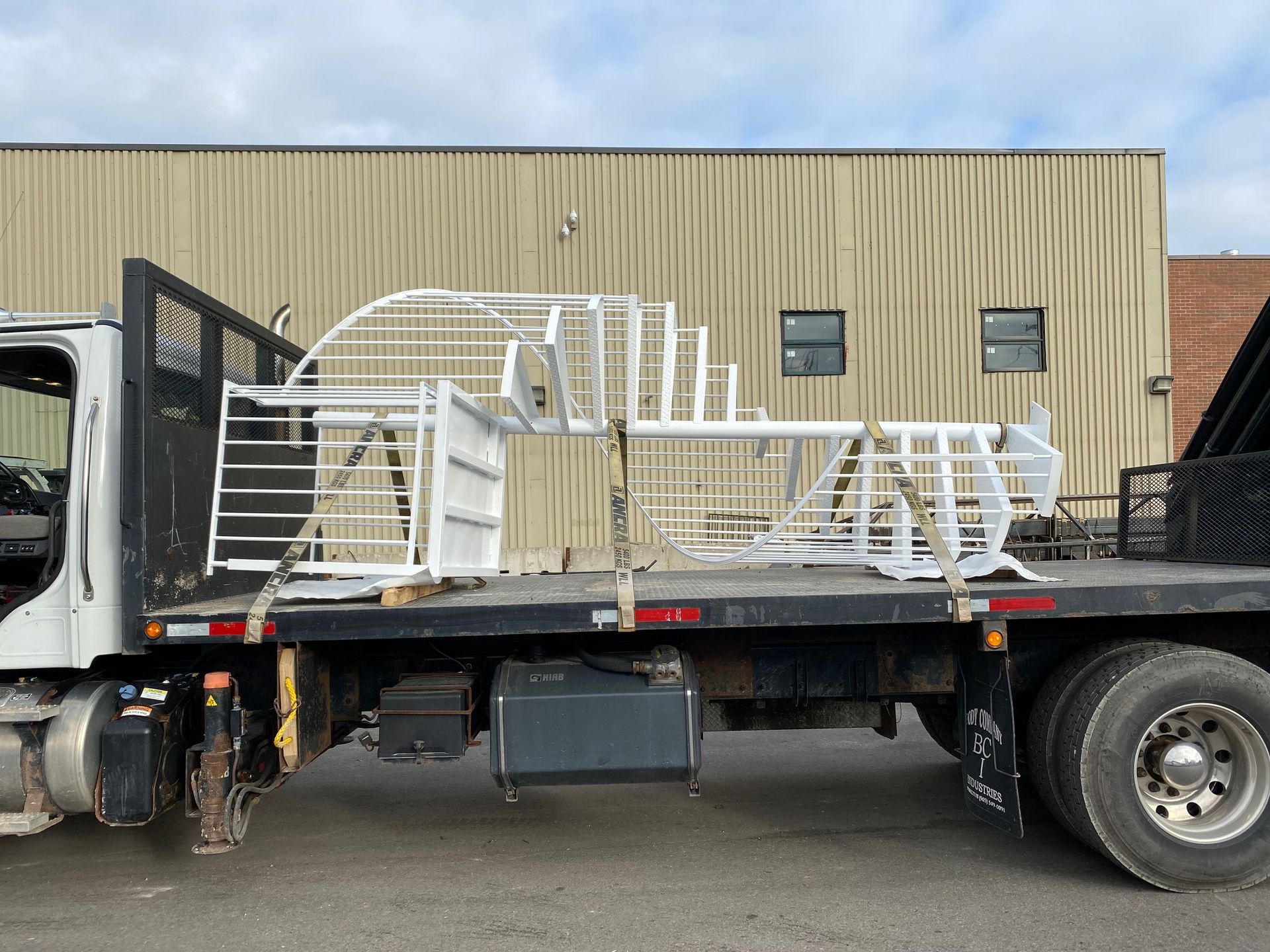 A flatbed truck is parked in front of a building
