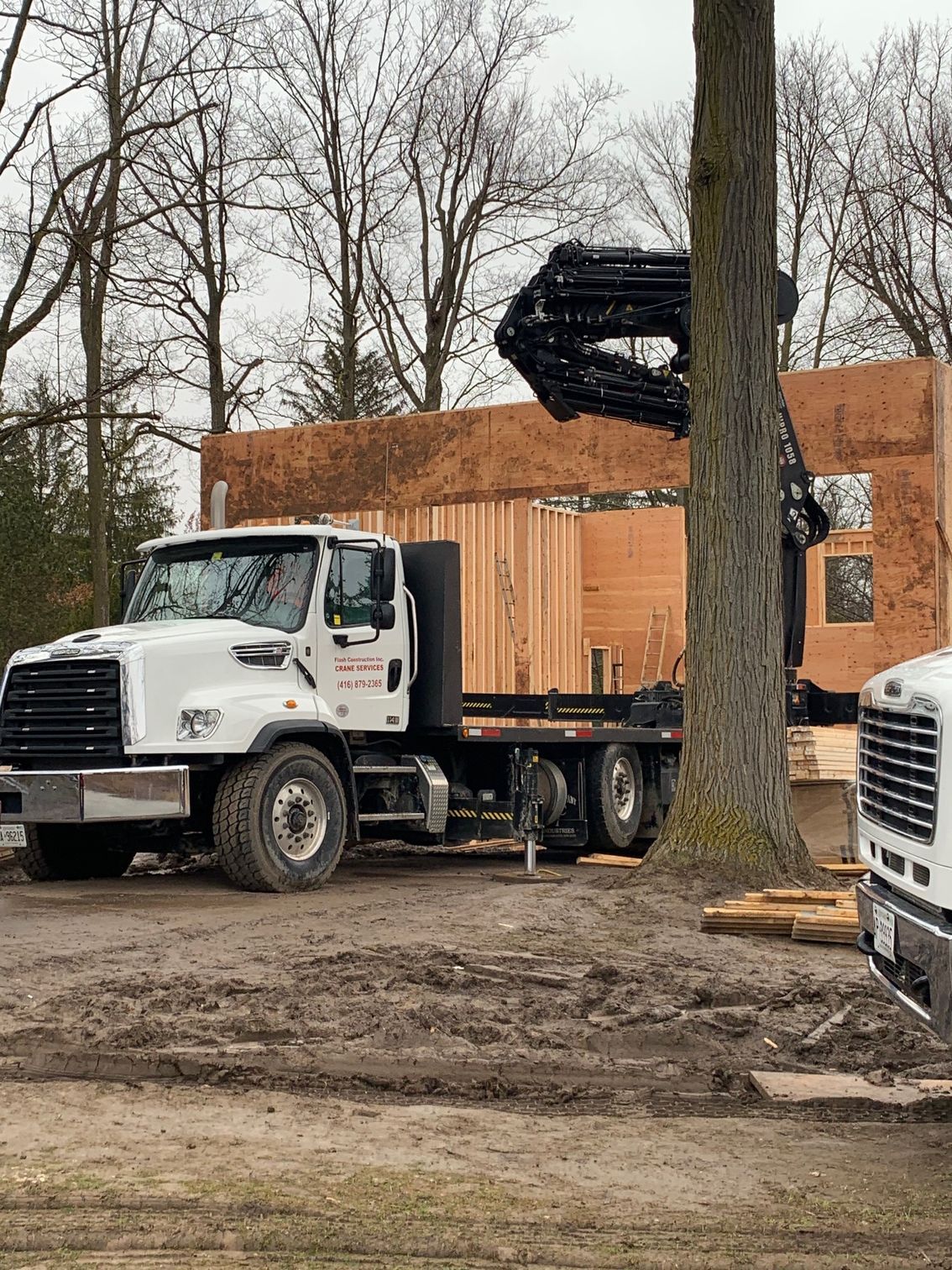 A truck is parked in front of a building under construction.
