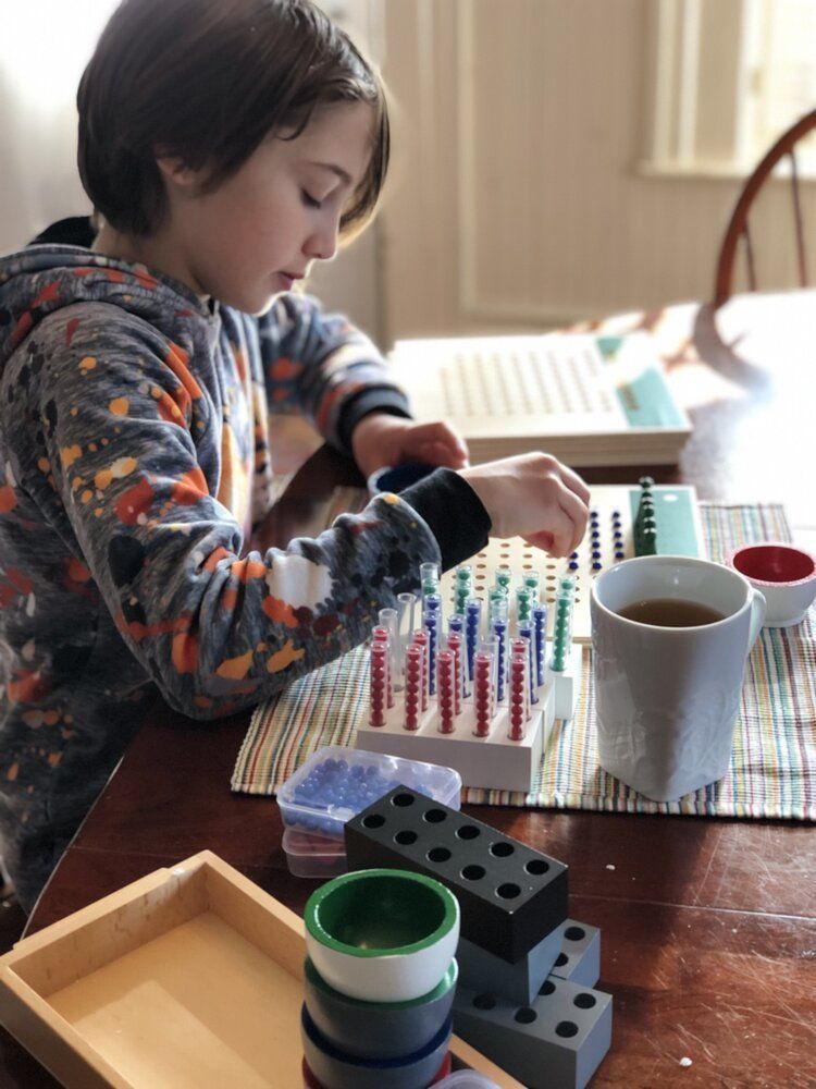 Montessori working with Montessori materials at a table