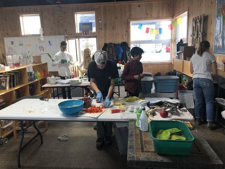 Montessori students food in a classroom kitchen with bowls, ingredients, and a window in back