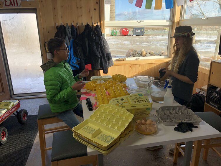 Two Montessori students cooking eggs