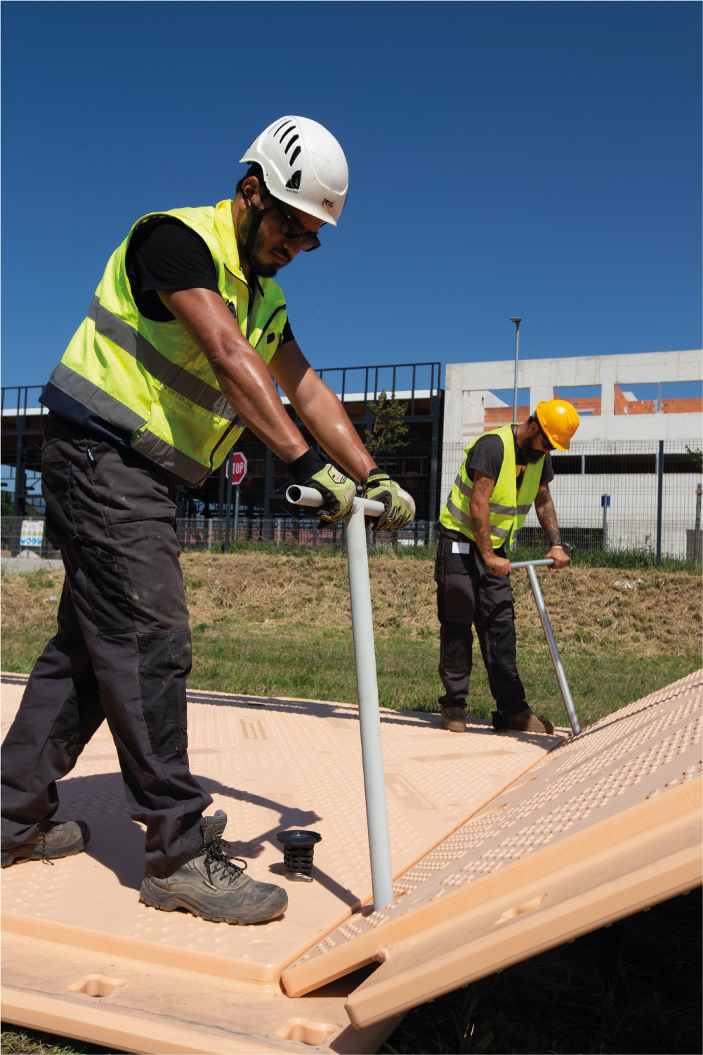 Dos trabajadores de la construcción están instalando Isotrack.