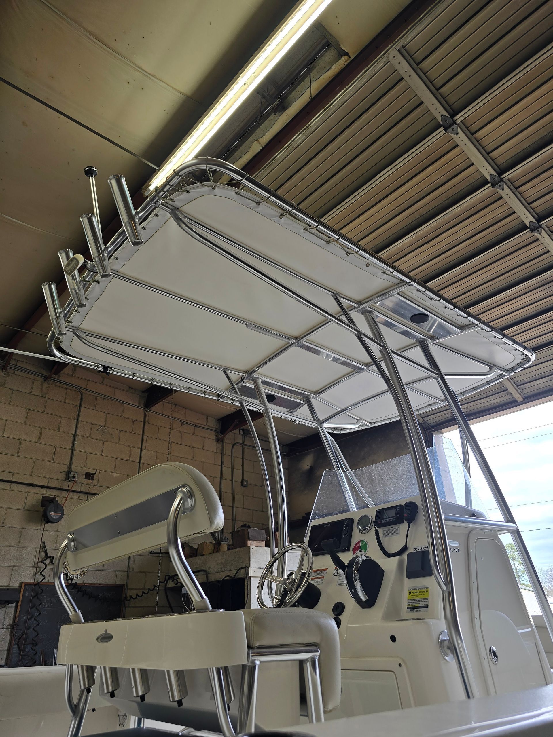 White boat on a lift inside a covered storage shed