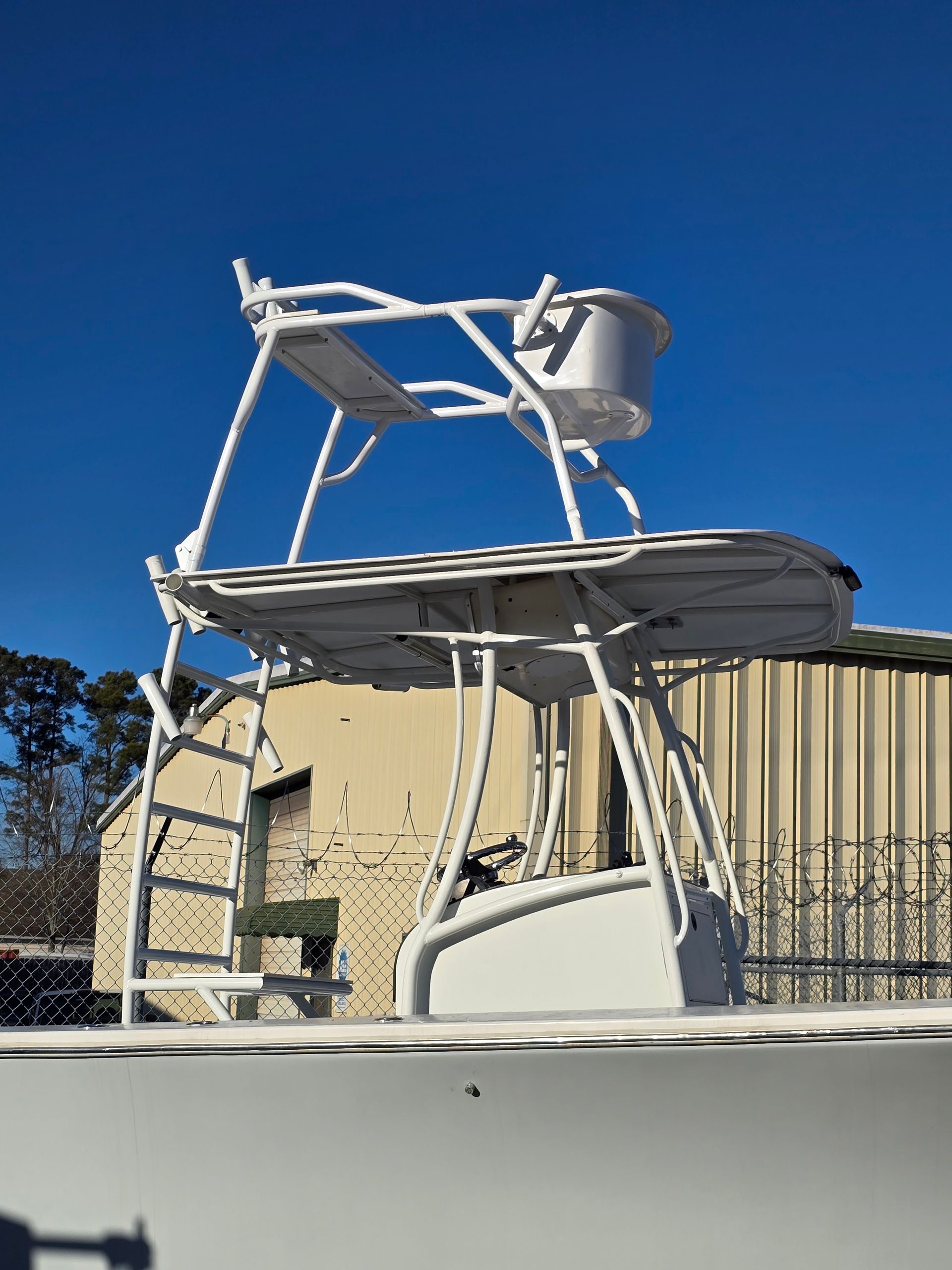 White boat tower with chair on a boat deck against a clear blue sky