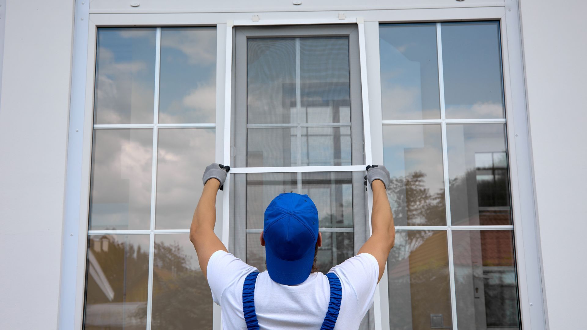 A man is installing a sliding glass door in a house.