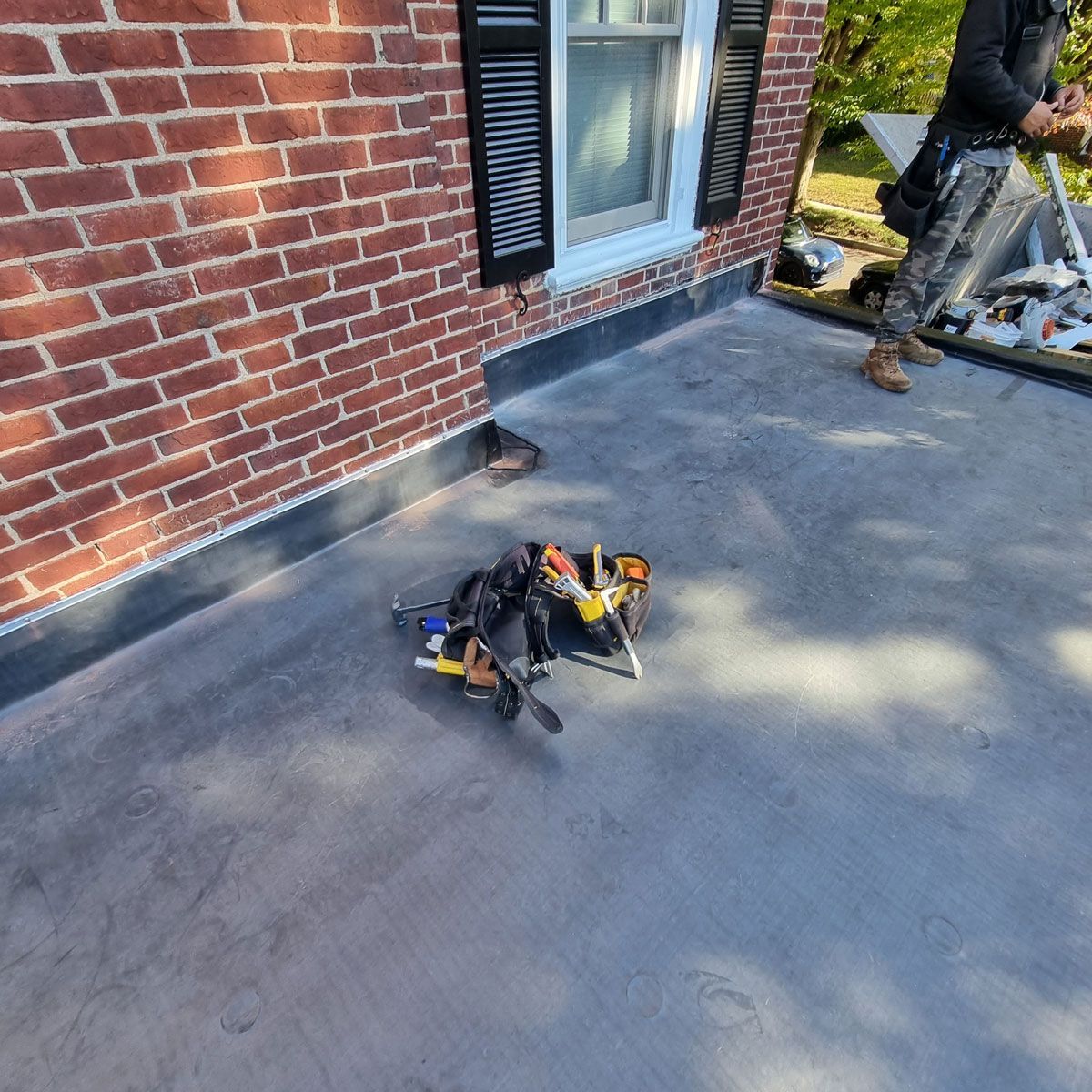 Man Standing on a Roof Next to a Brick Building - New Castle, DE - Macedo Mexpro LLC