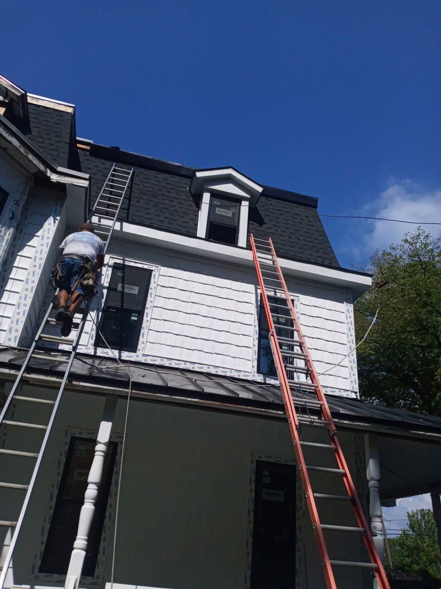 Man Standing on a Ladder on the Roof of a House - New Castle, DE - Macedo Mexpro LLC