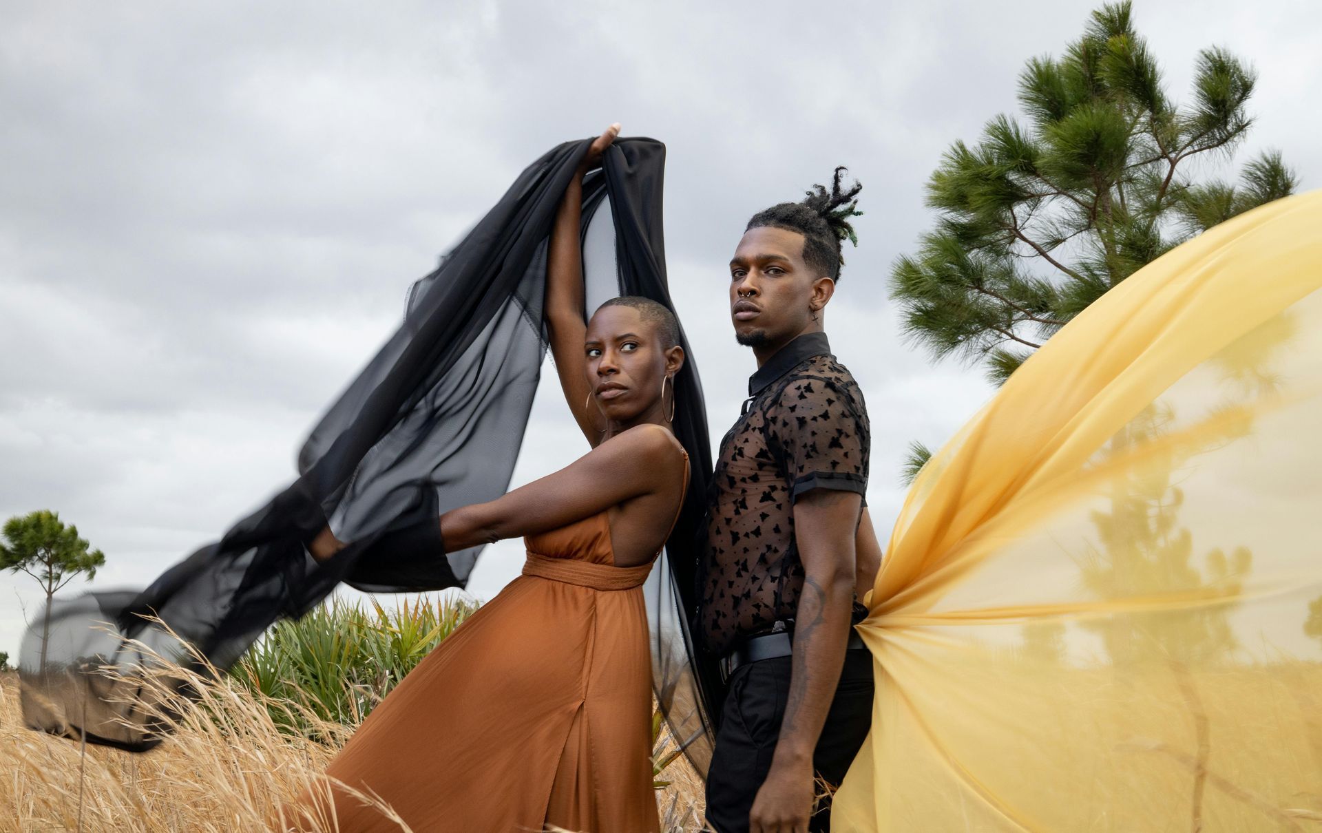 A man and a woman are standing next to each other in a field.
