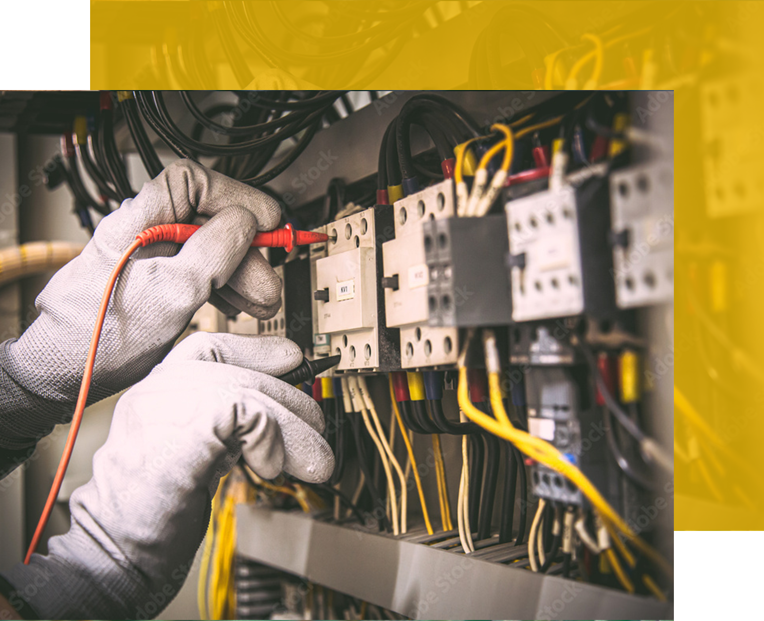 An electrician in gloves testing electrical wiring in an industrial control panel.