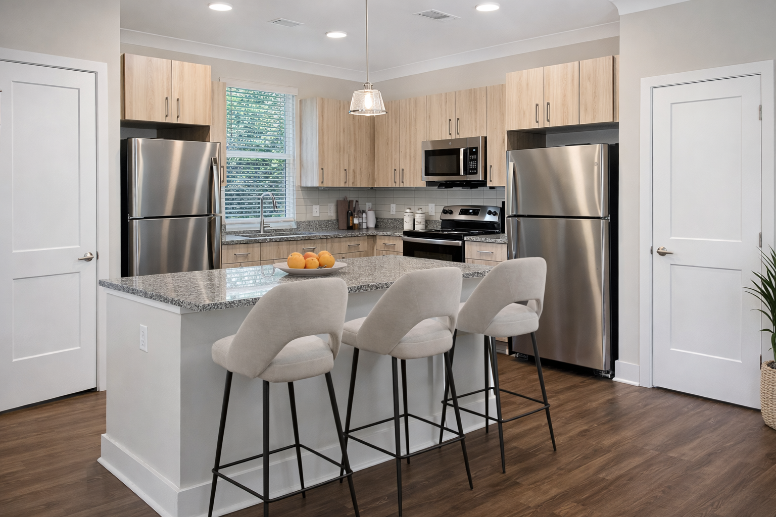Modern kitchen with granite countertops, stainless steel appliances, and an island with seating.