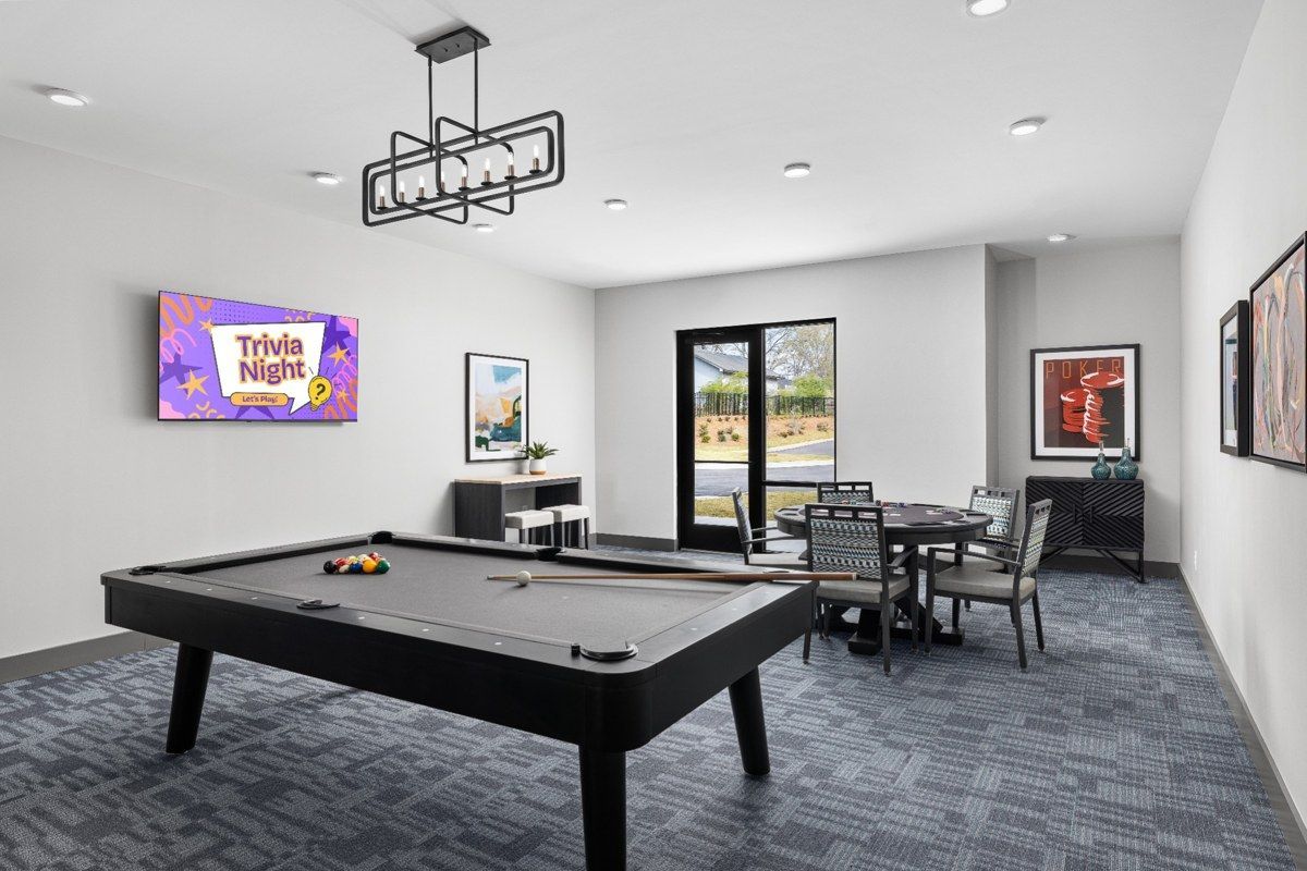 Game room with a pool table, TV, seating area, and large windows