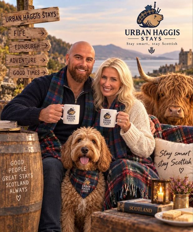 Smiling couple and fluffy dog holding mugs in a rustic Highland outdoor setting with Urban Haggis sign