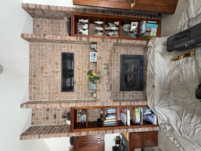 Brick fireplace wall with black insert and built-in wooden bookcases on both sides
