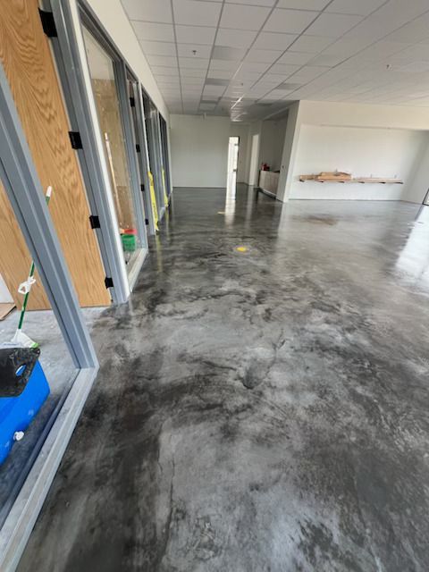 Empty industrial hallway with glossy concrete floor and glass doors on the left