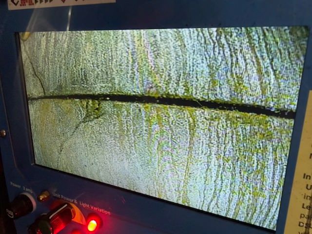 Damaged CRT monitor with a cracked, yellow-green static screen and a glowing red indicator light