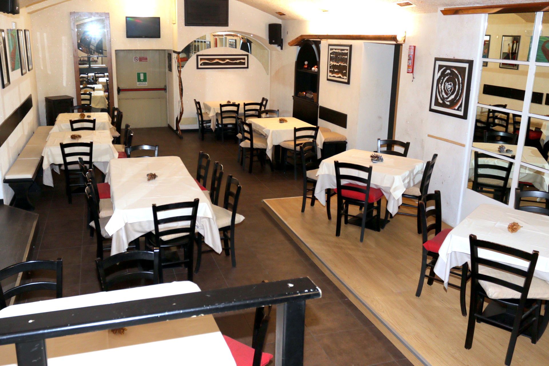 Un ristorante con tavoli e sedie e un'uscita antincendio