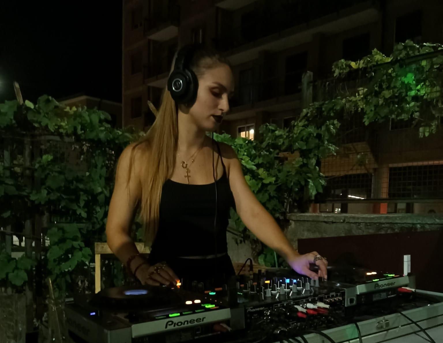 Una donna che indossa le cuffie sta riproducendo musica su un controller per dj Pioneer.