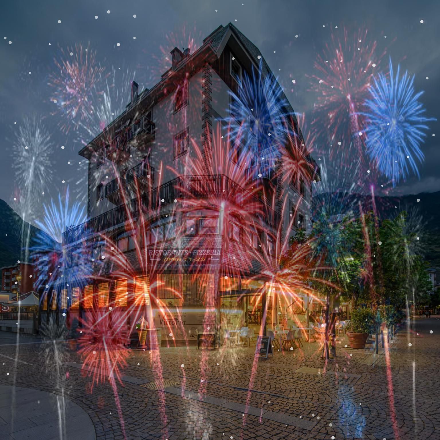 Fuochi d'artificio esplodono nel cielo di fronte a un edificio.