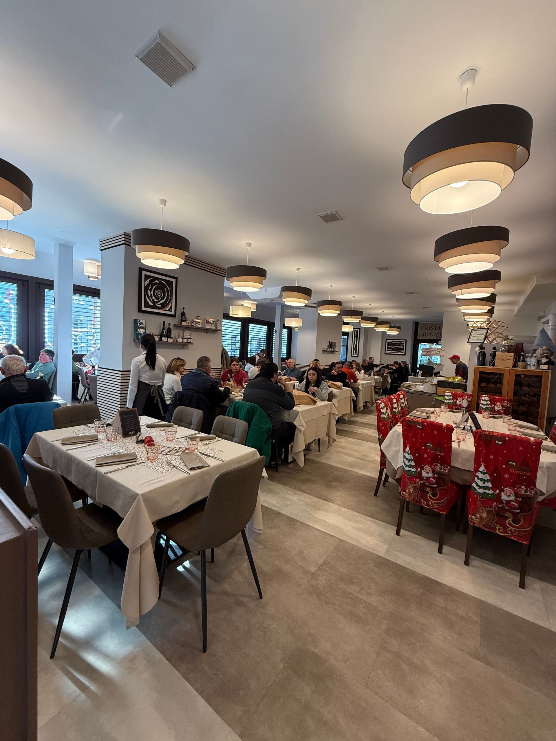 Una grande sala da pranzo piena di tavoli e sedie.