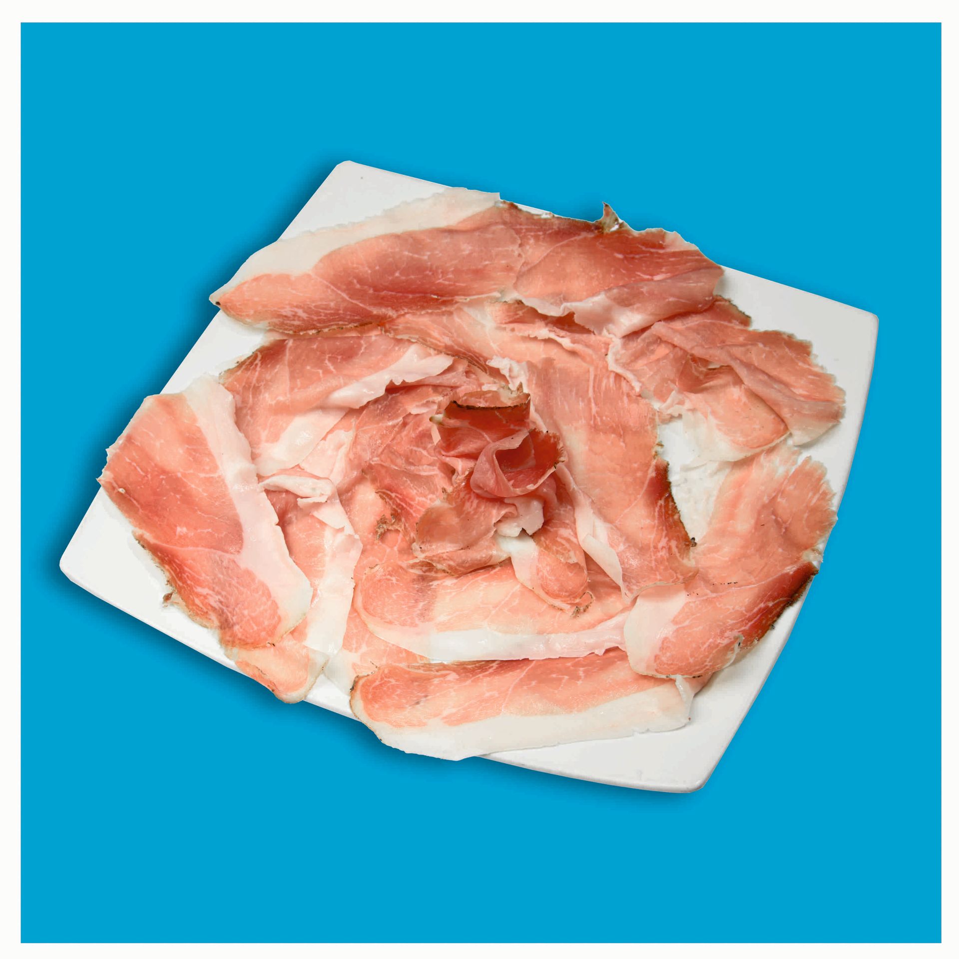 Un piatto di speck christanell prosciutto affumicato è appoggiato su un tavolo
