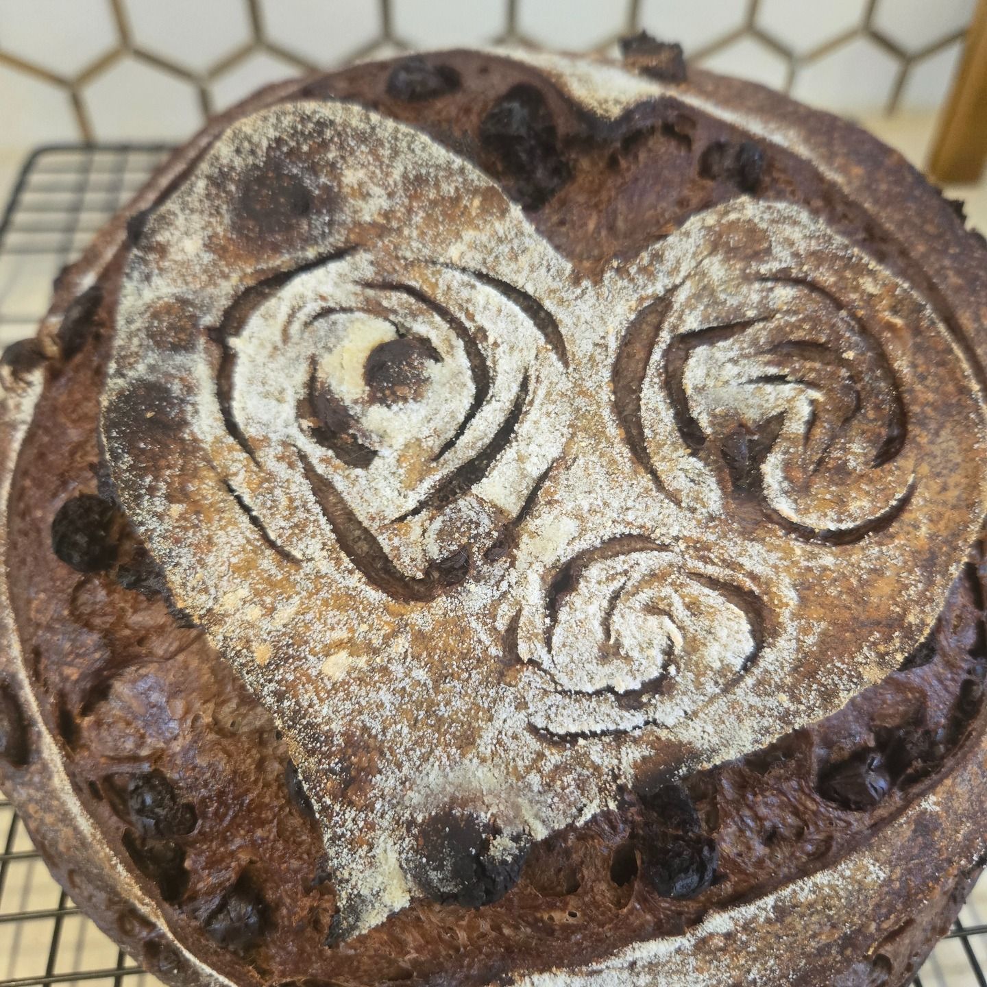 Round cookie with a powdered sugar face design on a plate, viewed from above