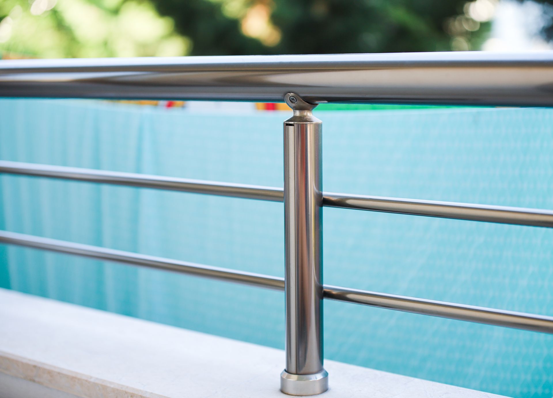Shiny, stainless steel railing with horizontal bars on a light blue backdrop.