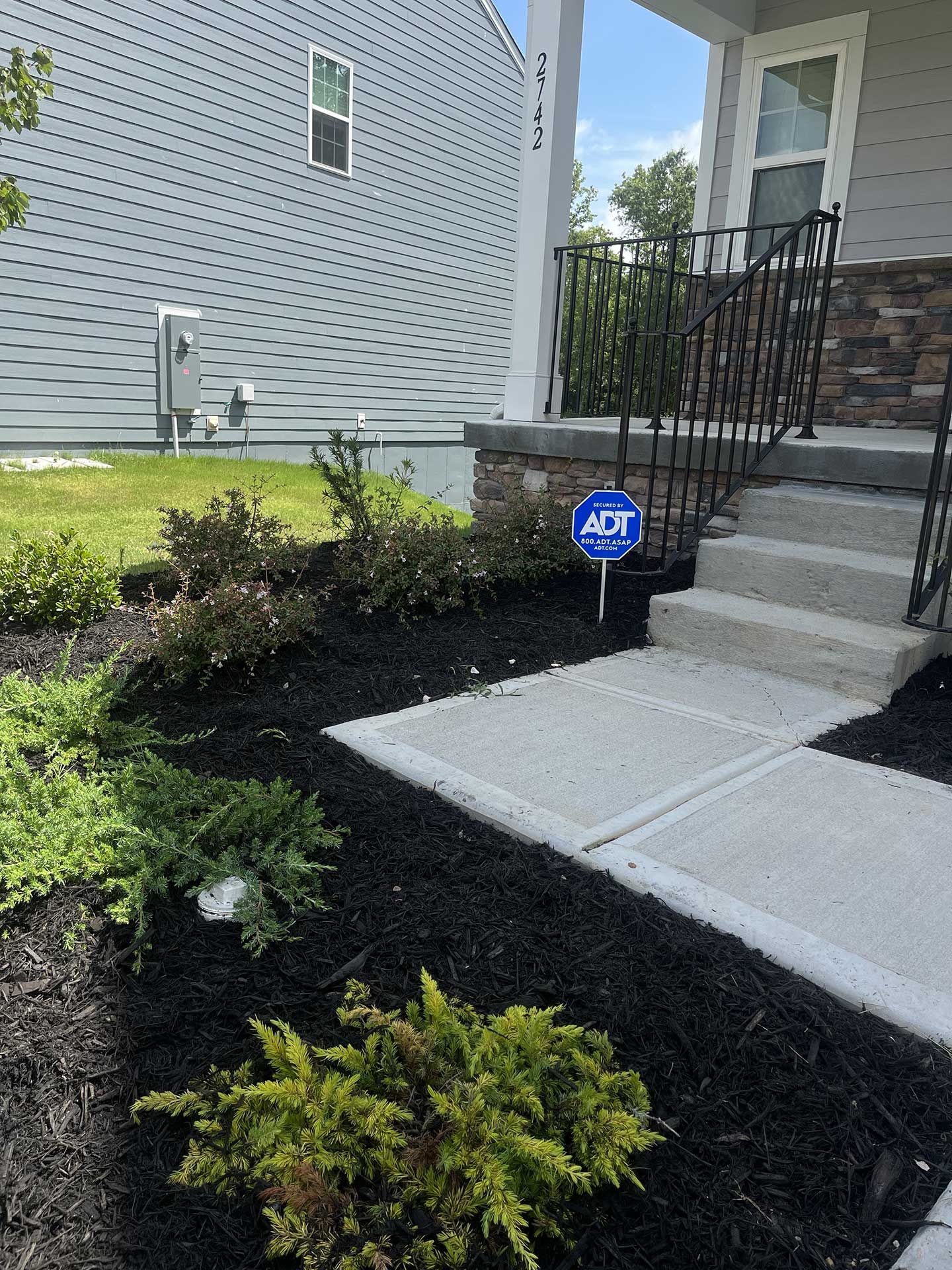 A house with a sign in front of it that says adt on it.