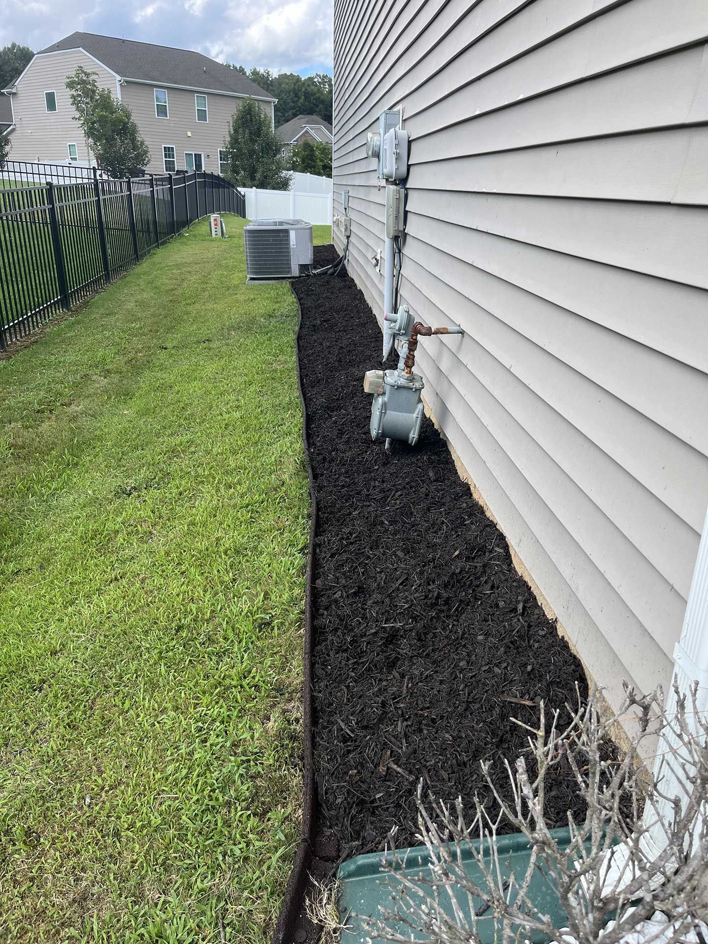 A house with a fence and a lawn in front of it.