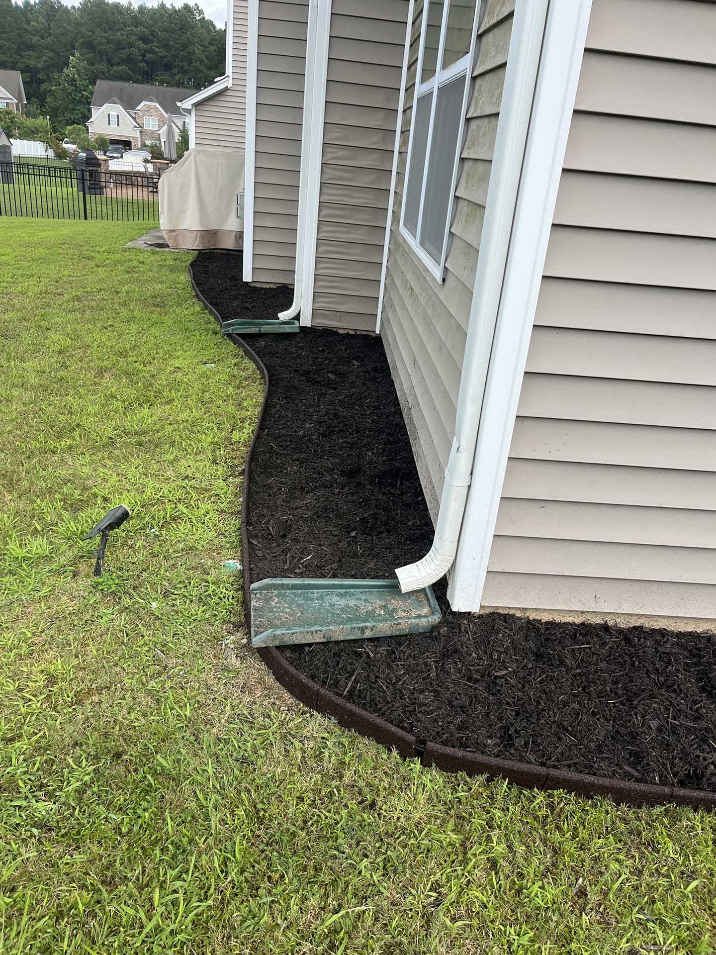 A house with a lot of mulch on the side of it.