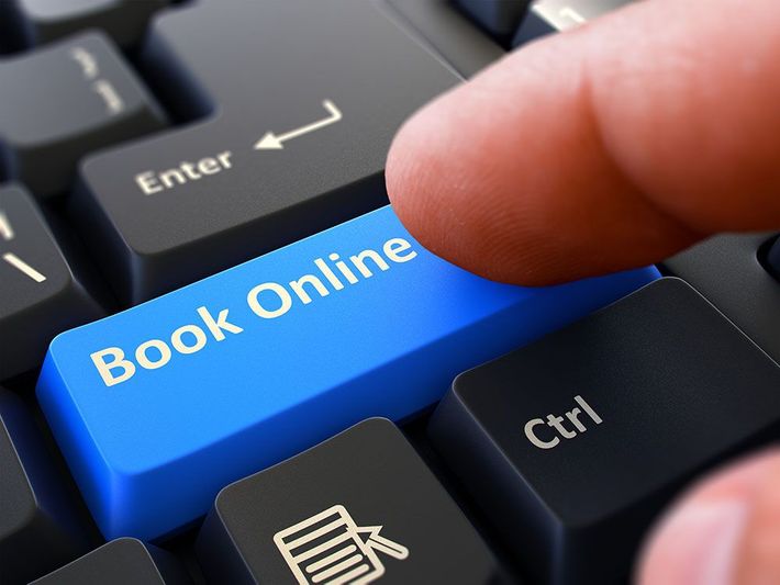 A person is pressing a blue book online key on a keyboard