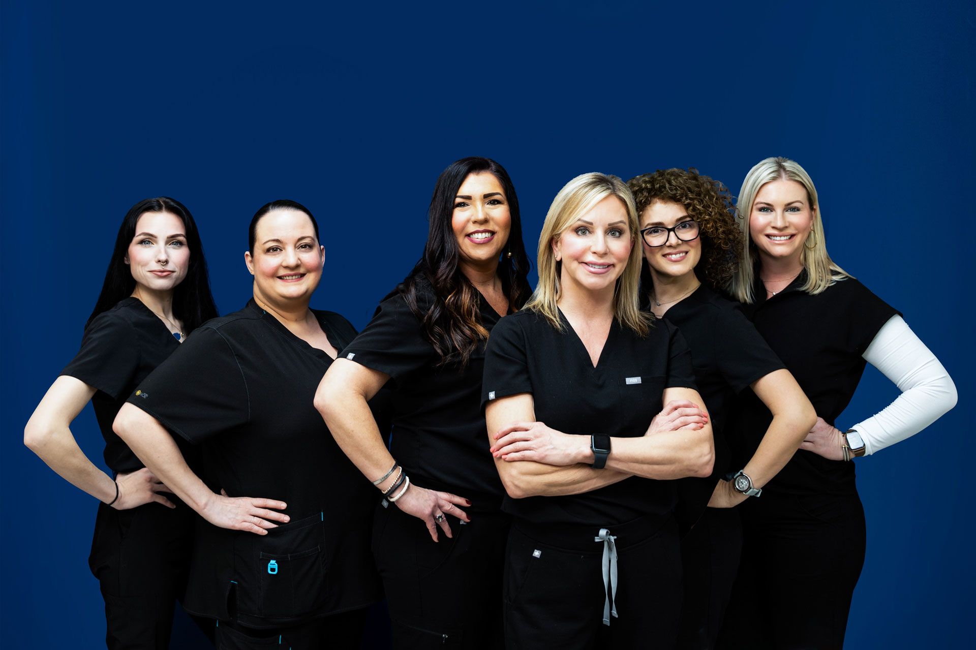 A group of women in scrubs are posing for a picture.