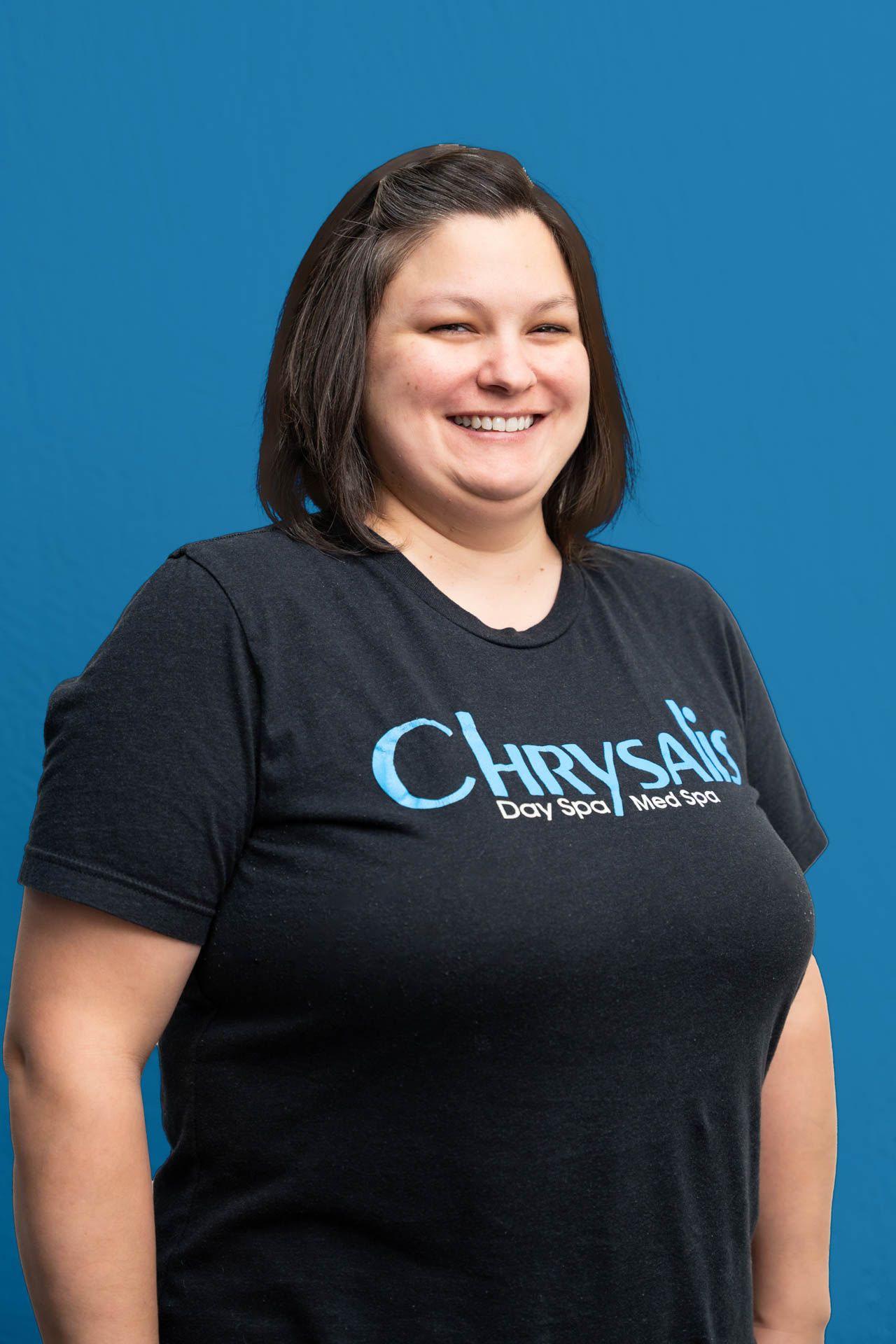 A woman is wearing a black t-shirt with the word chrysalis on it.