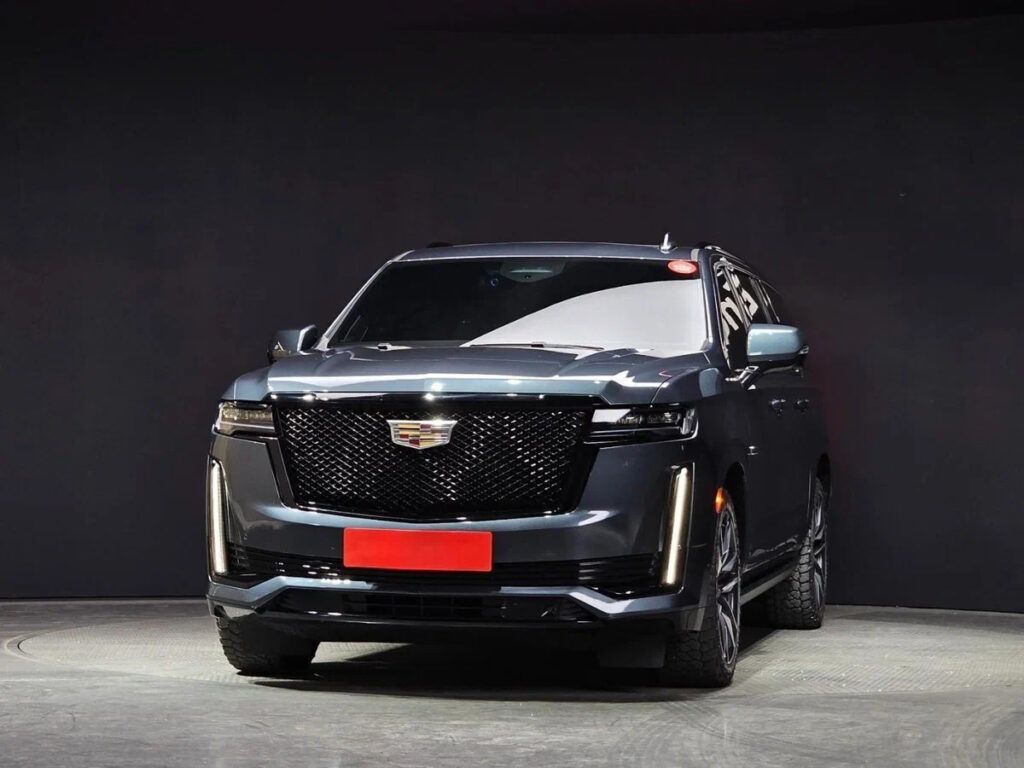 Black Cadillac SUV front view in a studio setting with a red-covered license plate