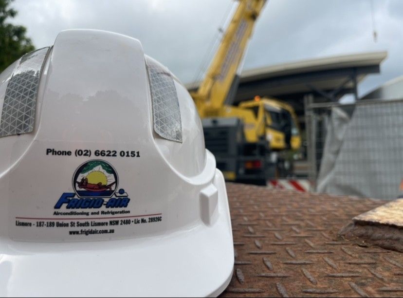A Crane That Is Lifting An Air Conditioner — Frigid-Air PTY Ltd In South Lismore, NSW