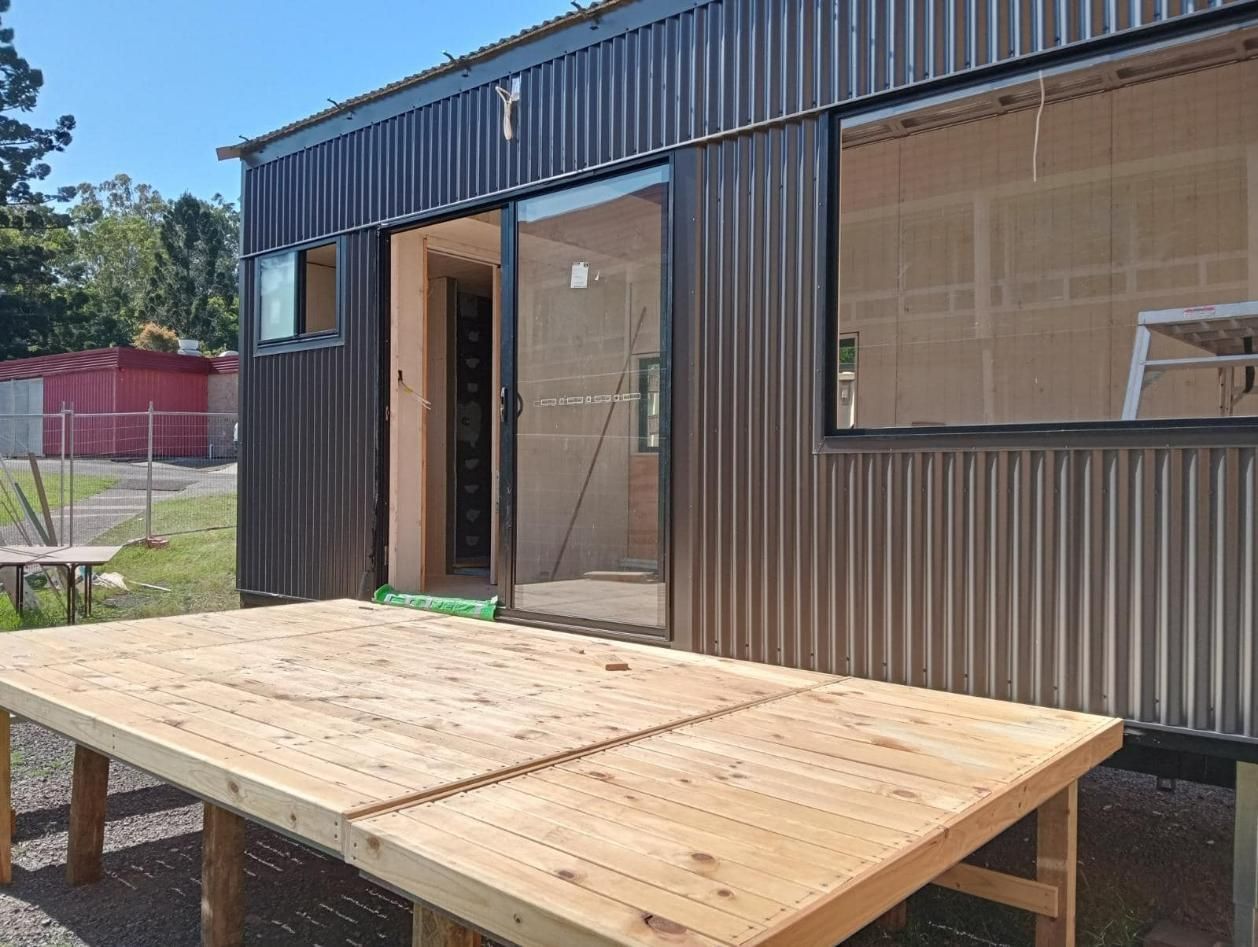 A Wooden Table Is Sitting In Front Of A Building — Frigid-Air PTY Ltd In Lennox Head, NSW