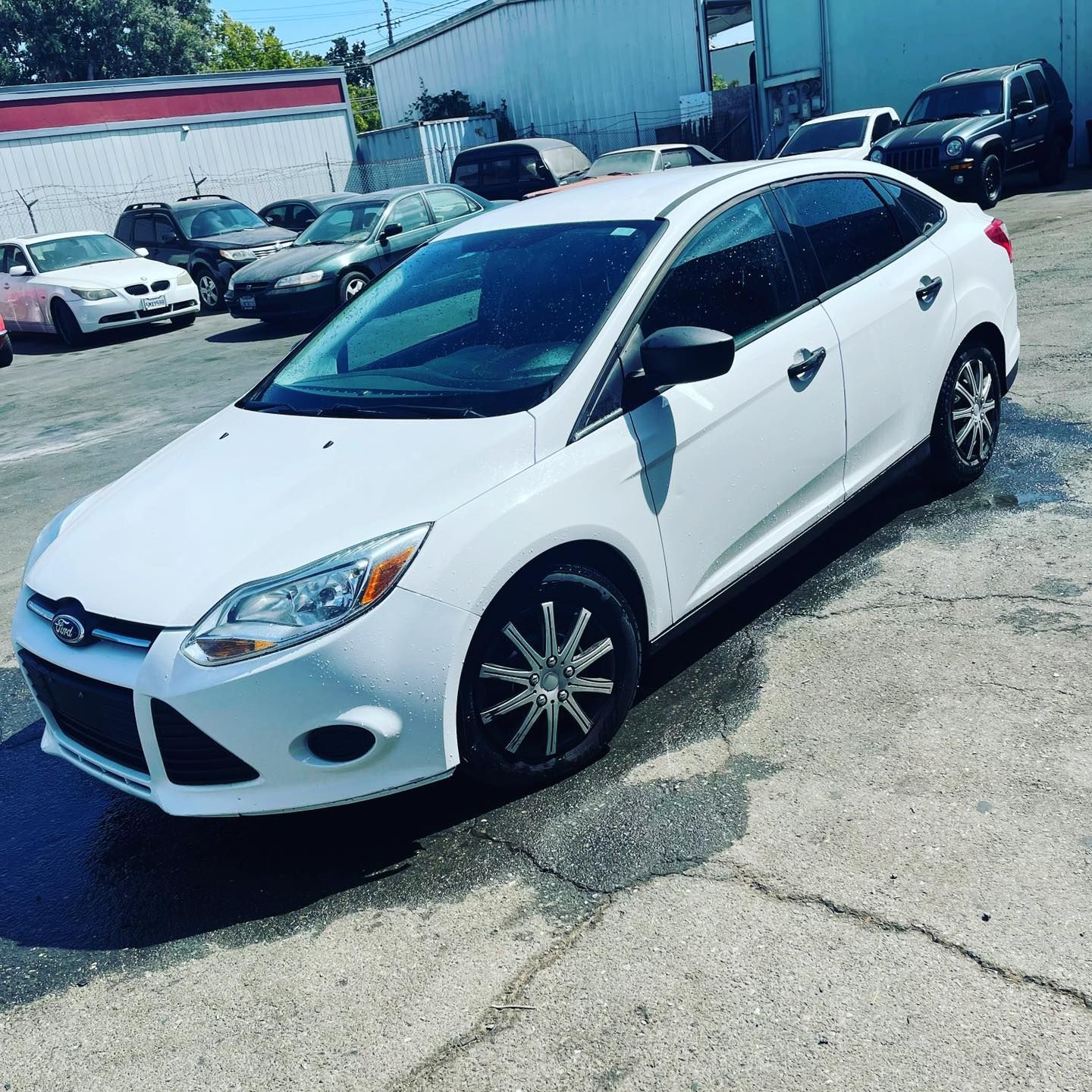 A white ford focus is parked in a parking lot.