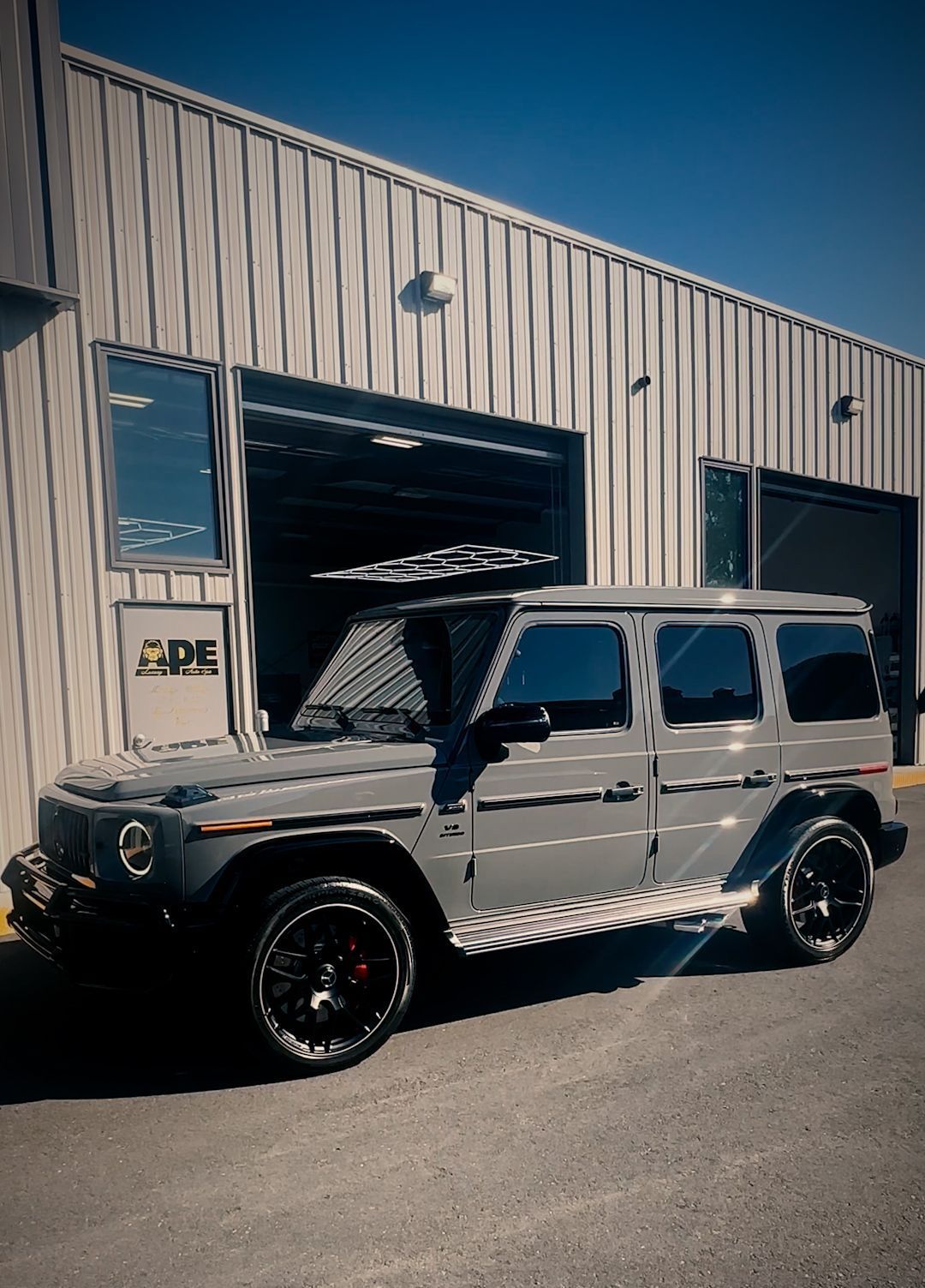 A gray jeep is parked in front of a building
